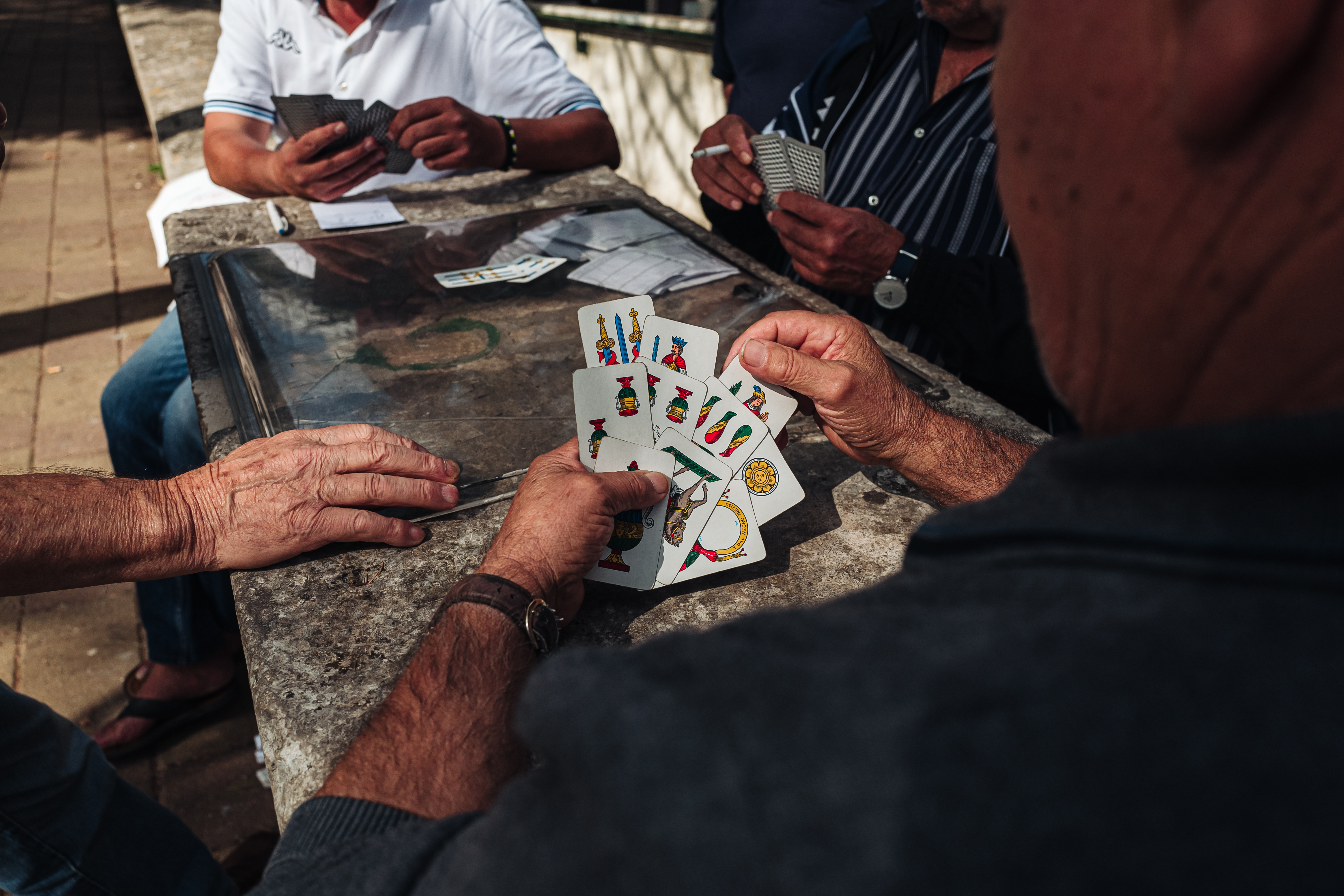 MARTINA FRANCA, ITALY / SEPTEMBER 2019: Old mens playing traditional card game in the parc